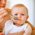 Young mother feeding adorable baby